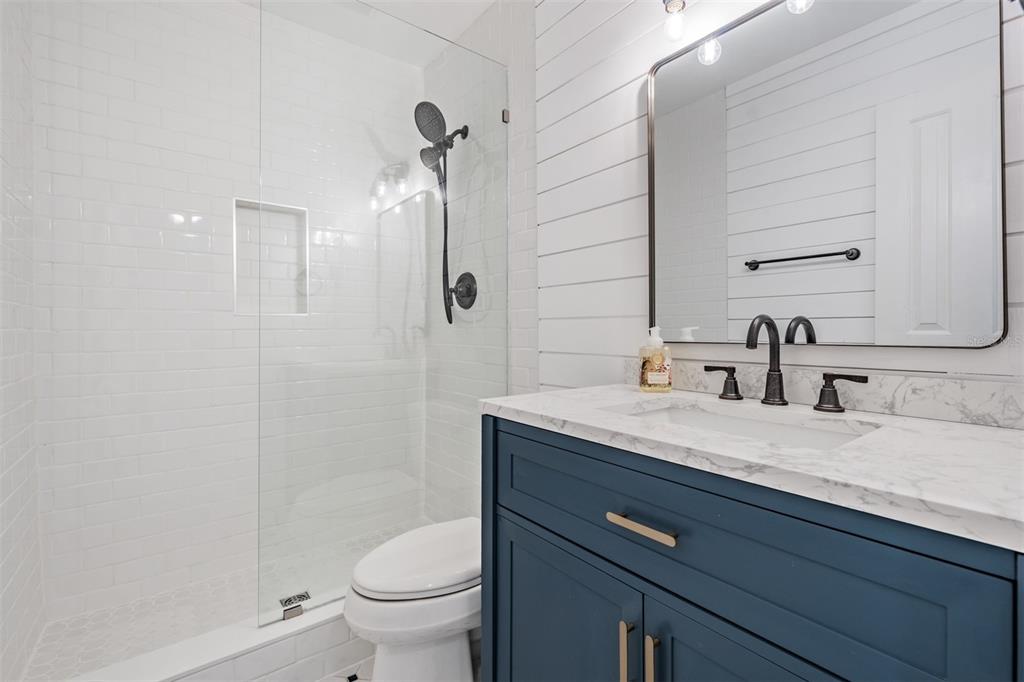 615 North Mayo Street Palm Harbor, FL 34683 - Photo 36 of 73 a bathroom with a granite countertop sink a toilet and a mirror