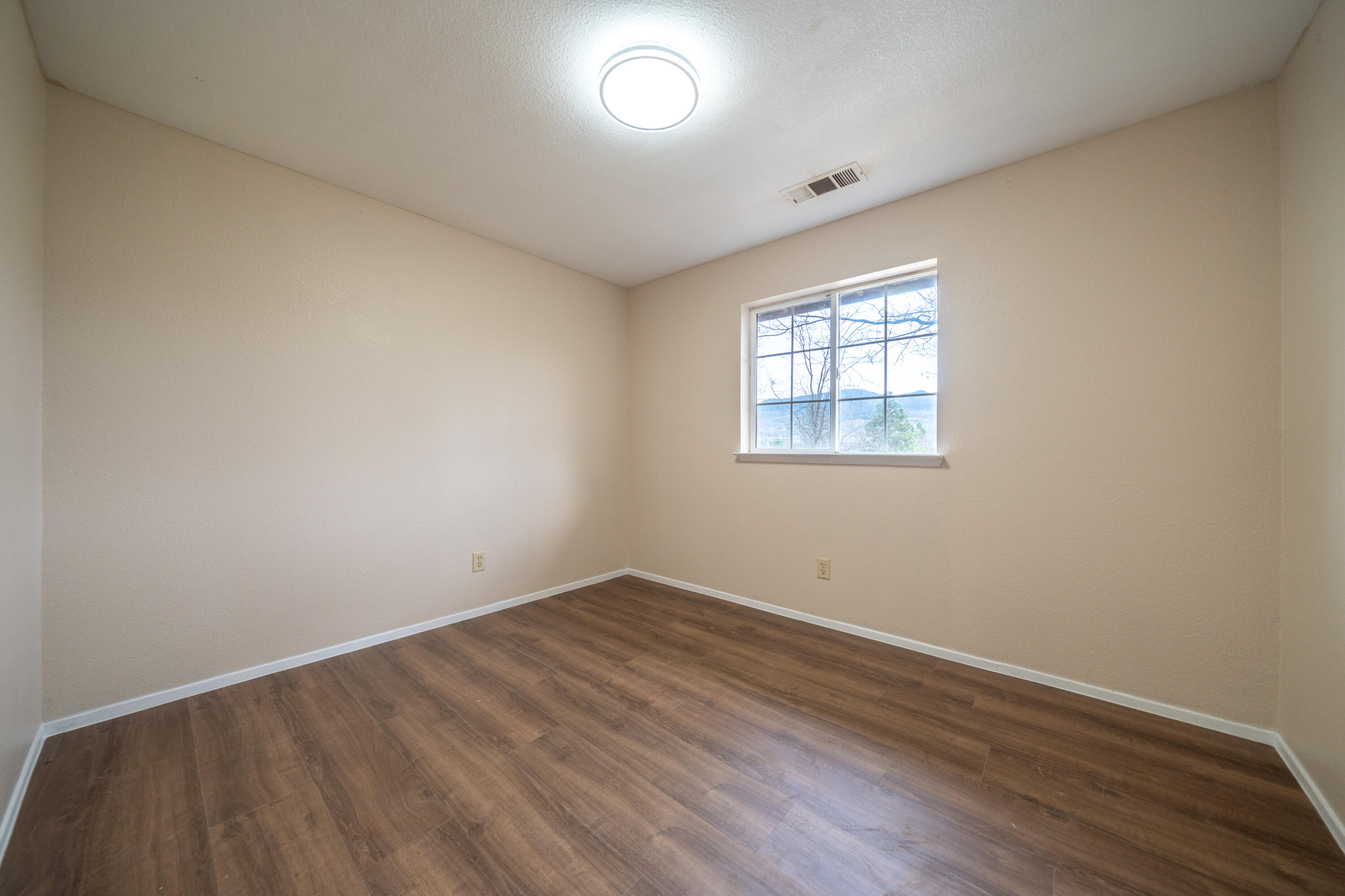 29800 Ranch Road Montgomery Creek, CA 96065 - Photo 25 of 74 an empty room with wooden floor and windows