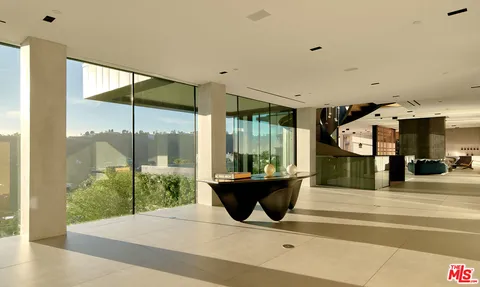 a living room with a large window and a chandelier