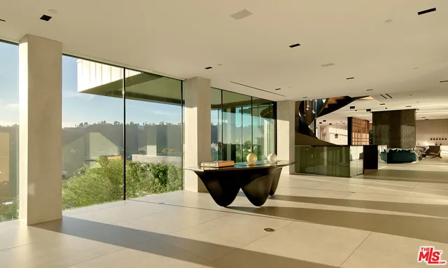 a living room with a large window and a chandelier