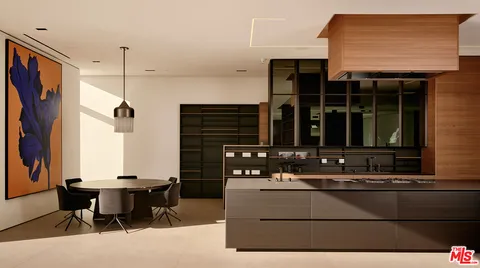 a kitchen with a refrigerator and chairs