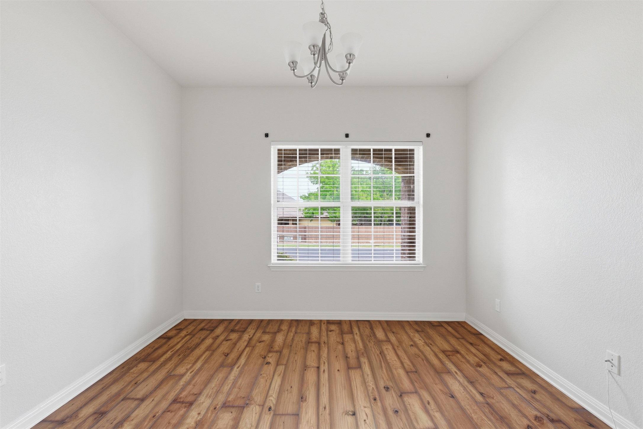339 Sycamore Street Georgetown, TX 78633 - Photo 17 of 28 Spare room with wood-type flooring and a chandelier