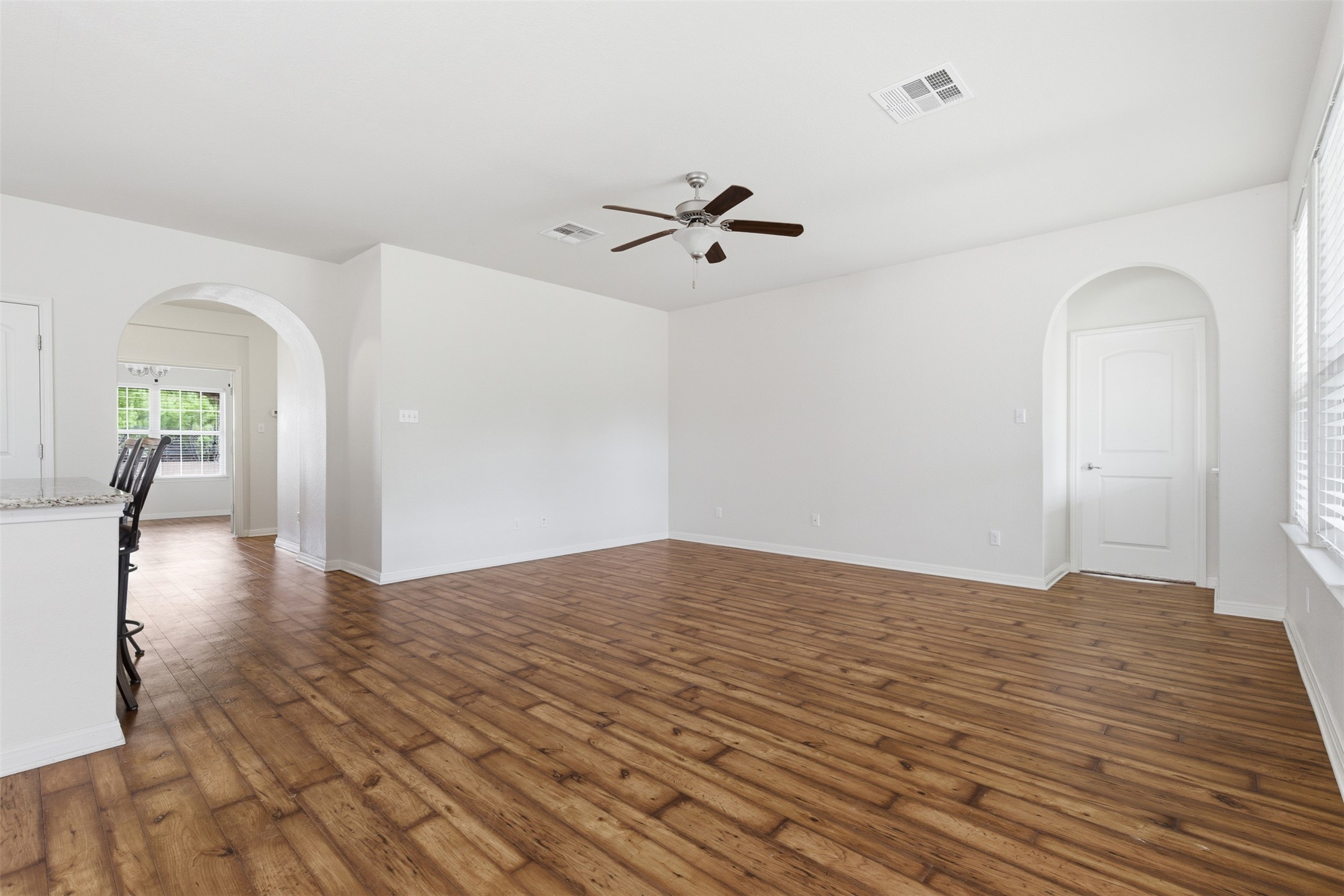339 Sycamore Street Georgetown, TX 78633 - Photo 8 of 28 Unfurnished room featuring arched walkways, ceiling fan, and dark wood finished floors