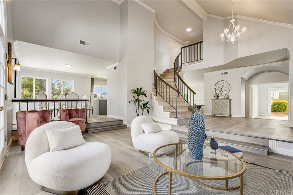 21626 Fairwind Lane Diamond Bar, CA 91765 - Photo 3 of 44 a living room with couches chandelier and a large mirror with wooden floor