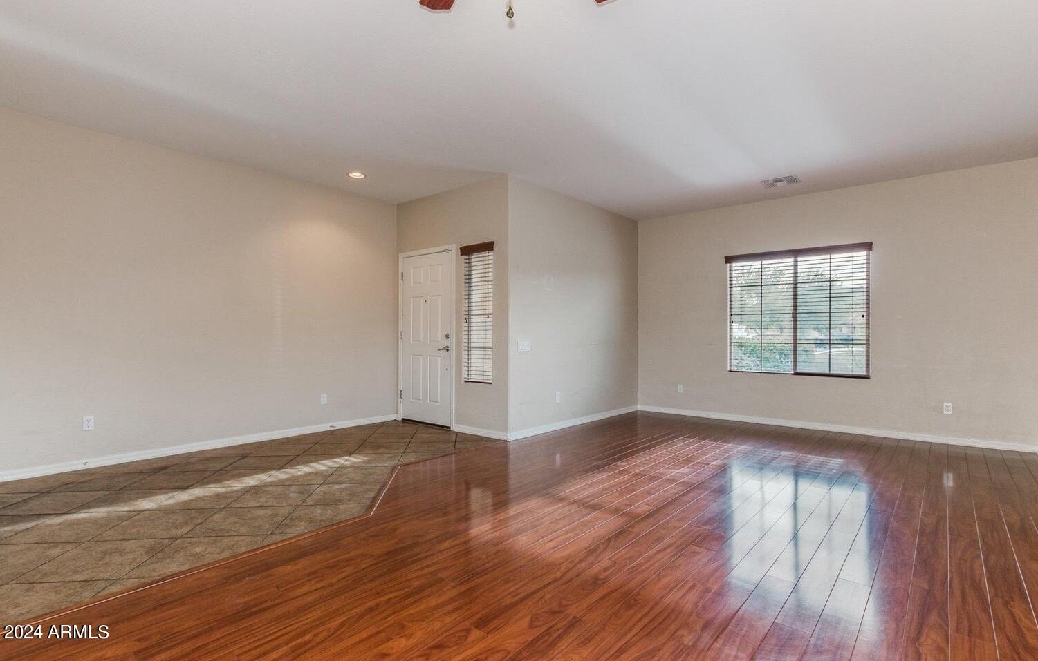 5230 West Red Bird Road Phoenix, AZ 85083 - Photo 2 of 26 an empty room with wooden floor and windows