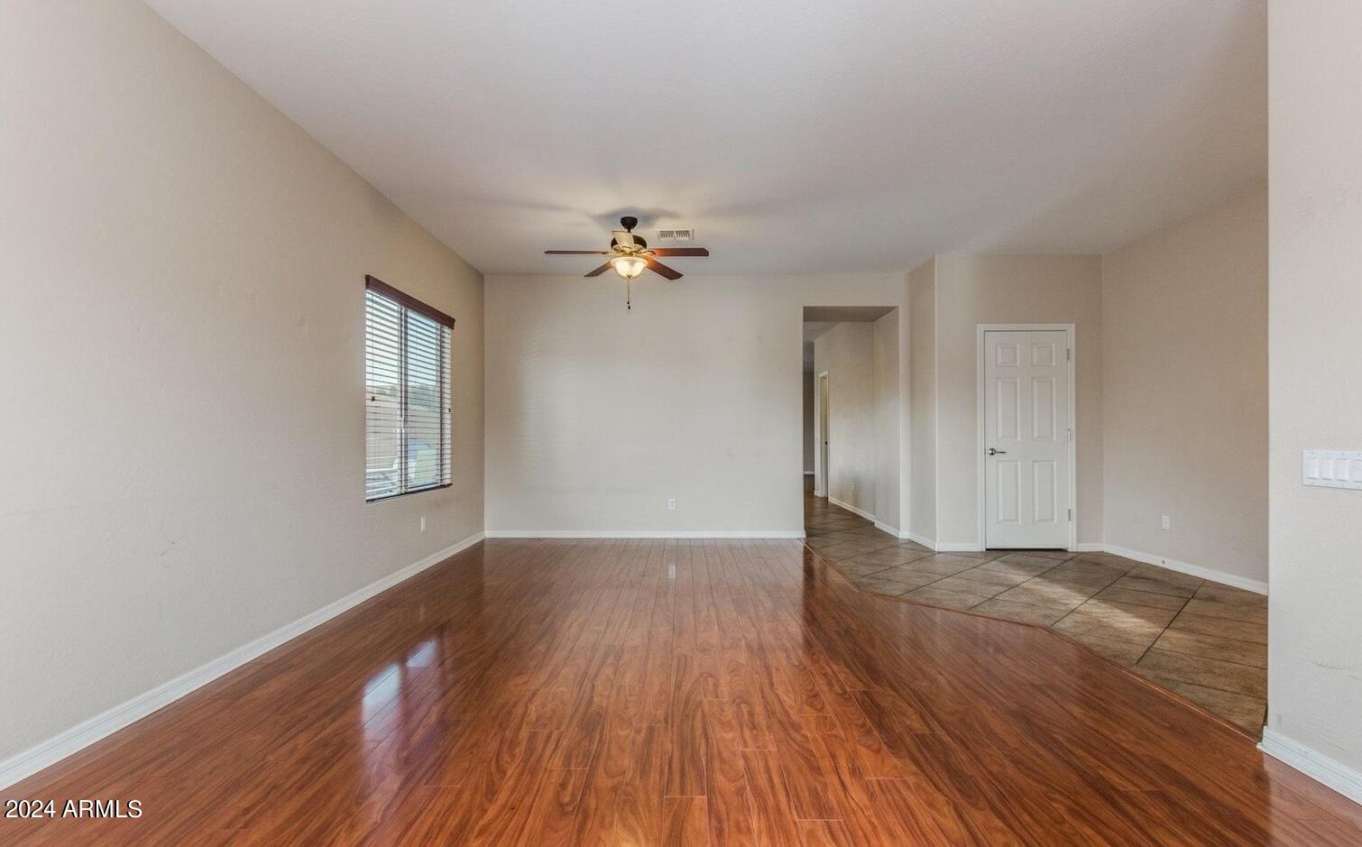 5230 West Red Bird Road Phoenix, AZ 85083 - Photo 3 of 26 a view of a livingroom with wooden floor and a ceiling fan