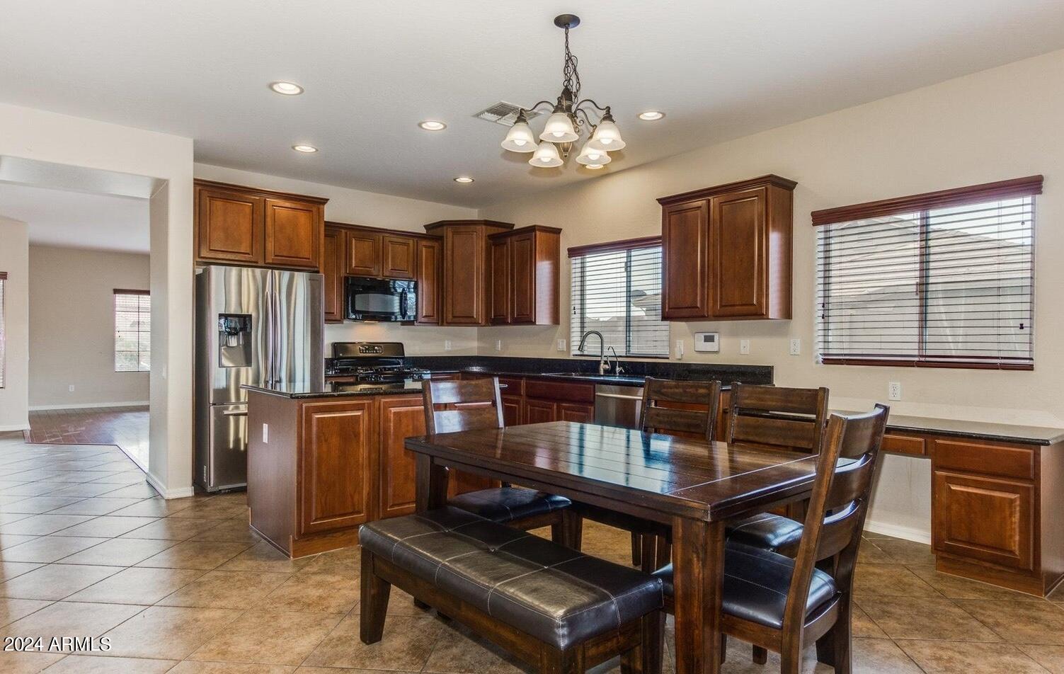 5230 West Red Bird Road Phoenix, AZ 85083 - Photo 4 of 26 a kitchen with stainless steel appliances granite countertop a stove a refrigerator a sink a stove with white cabinets and wooden floor