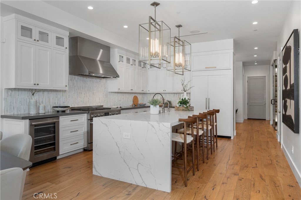 1004 Huntington Street Huntington Beach, CA 92648 - Photo 13 of 46 a kitchen with stainless steel appliances granite countertop a stove oven a refrigerator a sink and a dining table with wooden floor