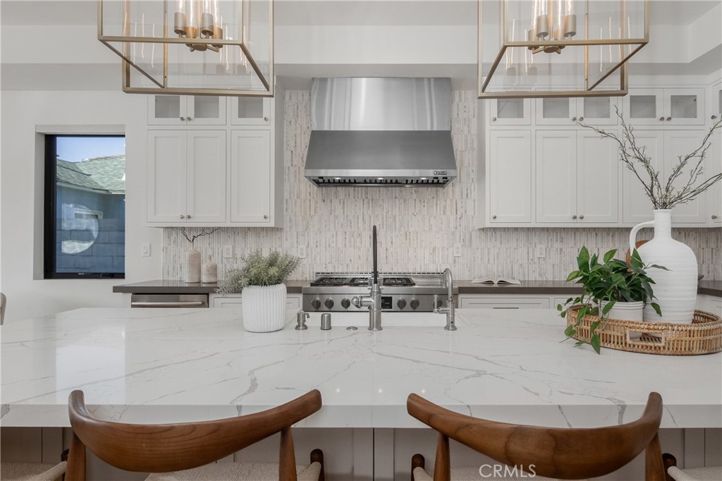 1004 Huntington Street Huntington Beach, CA 92648 - Photo 15 of 46 a kitchen with stainless steel appliances kitchen island granite countertop a table and chairs in it