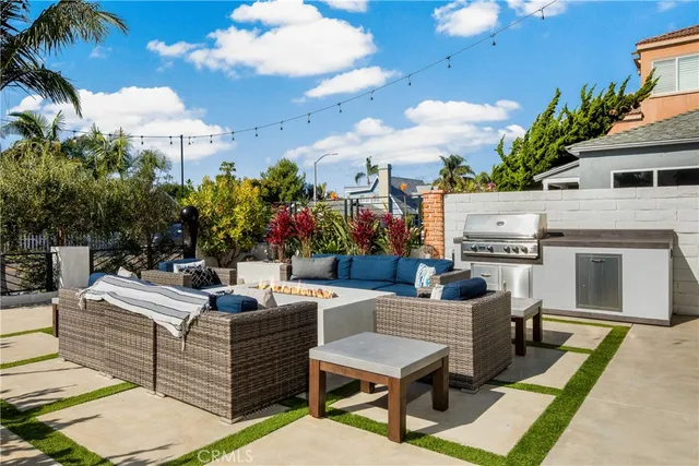 a view of a patio with couches table and chairs potted plants and palm tree