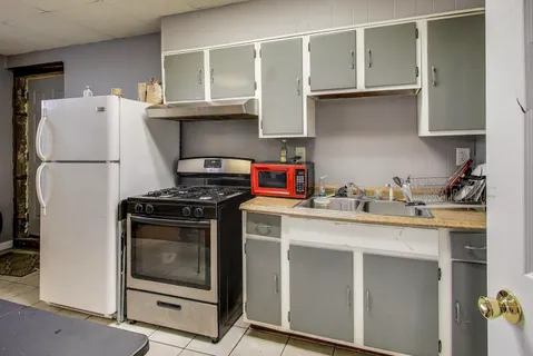 a kitchen with stainless steel appliances granite countertop a sink a stove and a refrigerator