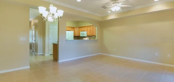 en empty room with a chandelier fan and a chandelier fan