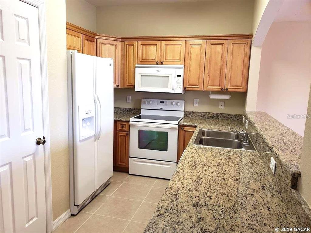 522 Northwest 39th Road, Unit 702 Gainesville, FL 32607 - Photo 7 of 15 a kitchen with a stove top oven and refrigerator