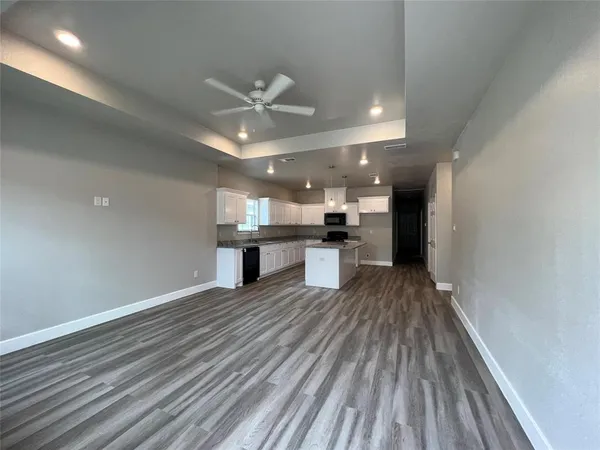 a view of kitchen with refrigerator stove and wooden floor