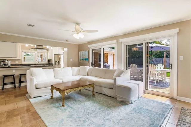 a living room with furniture and a view of kitchen