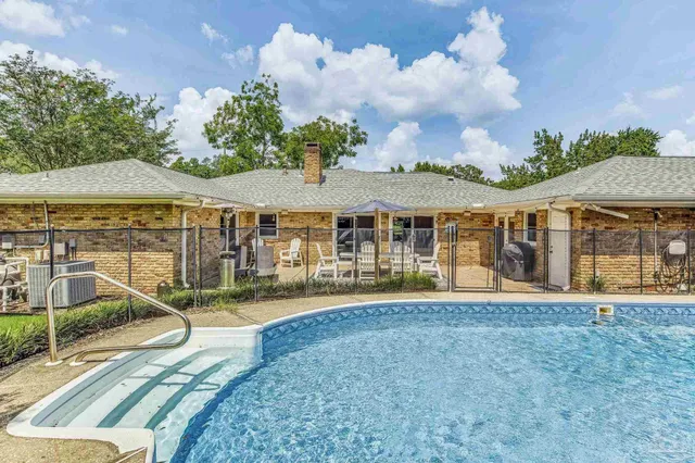 a view of a house with swimming pool and sitting area