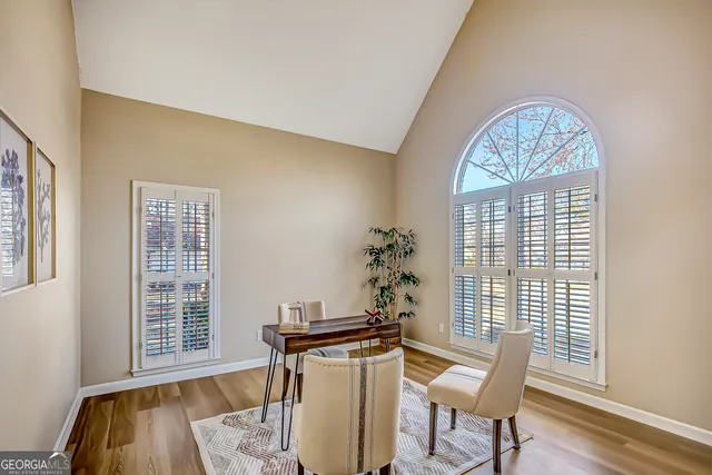 a dining room with furniture a chandelier and wooden floor