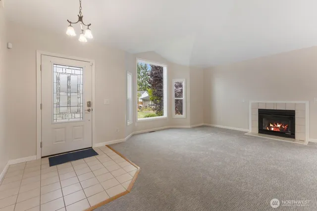 an empty room with windows and fireplace
