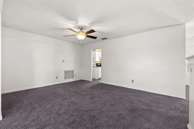 an empty room with a ceiling fan and a window