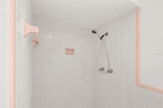 an empty room with chandelier fan and windows