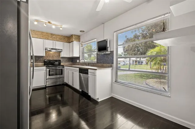 a kitchen with stainless steel appliances granite countertop a stove a sink and a refrigerator