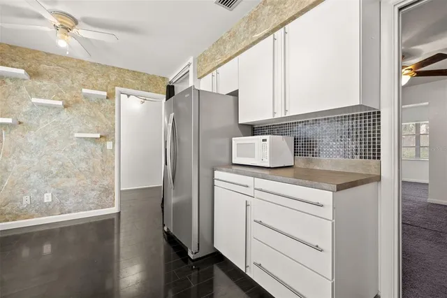 a kitchen with a refrigerator sink and cabinets