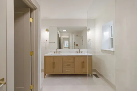a bathroom with a mirror sink and double vanity