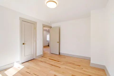 a view of a room with wooden floor and bathroom