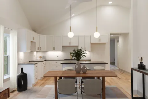 a kitchen with cabinets table and chairs
