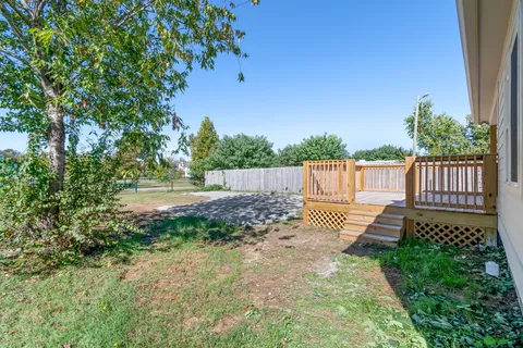 a view of a yard with wooden fence