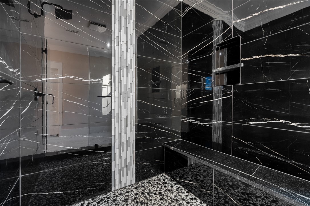 303 Regency Circle Anderson, SC 29625 - Photo 22 of 50 This spacious shower features sleek black tile and a mosaic accent, creating a luxurious spa-like retreat.
