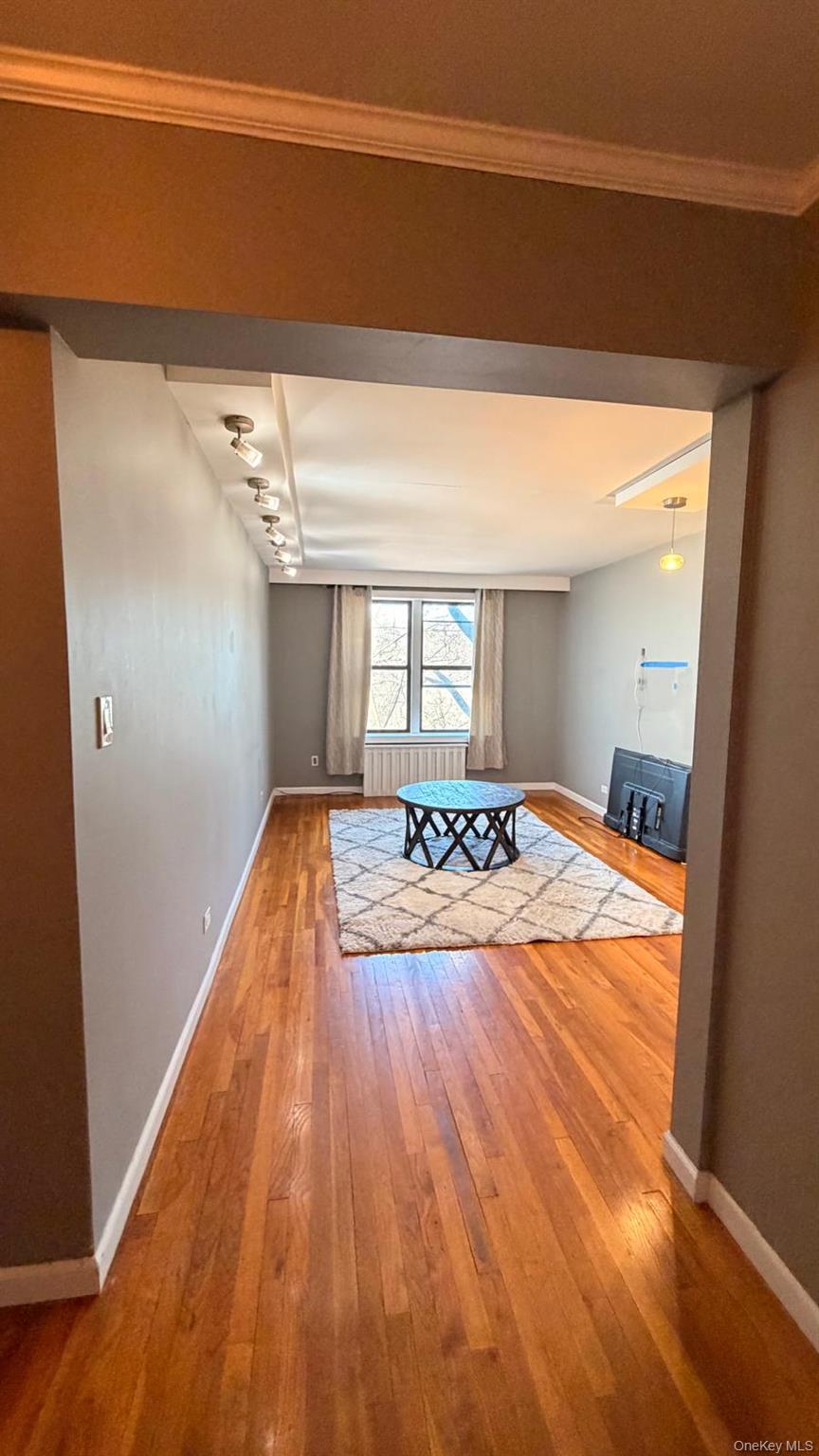 8305 98th Street, Unit 3C Queens, NY 11421 - Photo 2 of 19 a view of a bedroom with wooden floor and a bed
