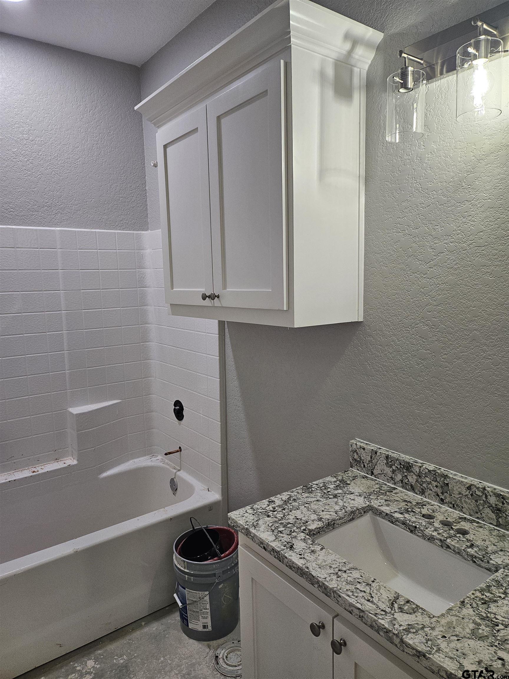 100 Cook Street, Unit 6 Arp, TX 75750 - Photo 4 of 8 a bathroom with a granite countertop sink a toilet and bathtub