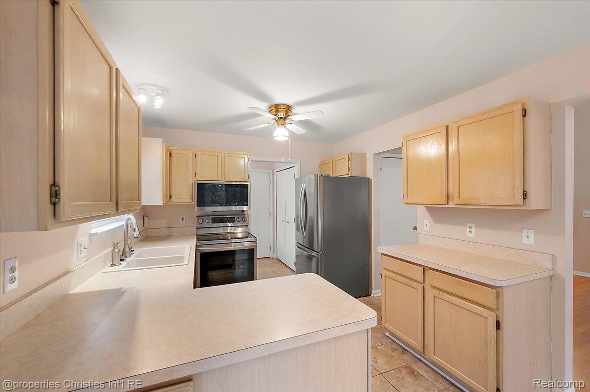 955 Rikki Ann Court Wixom, MI 48393 - Photo 29 of 54 Kitchen featuring light wood finish cabinets, stainless steel appliances, and light countertops