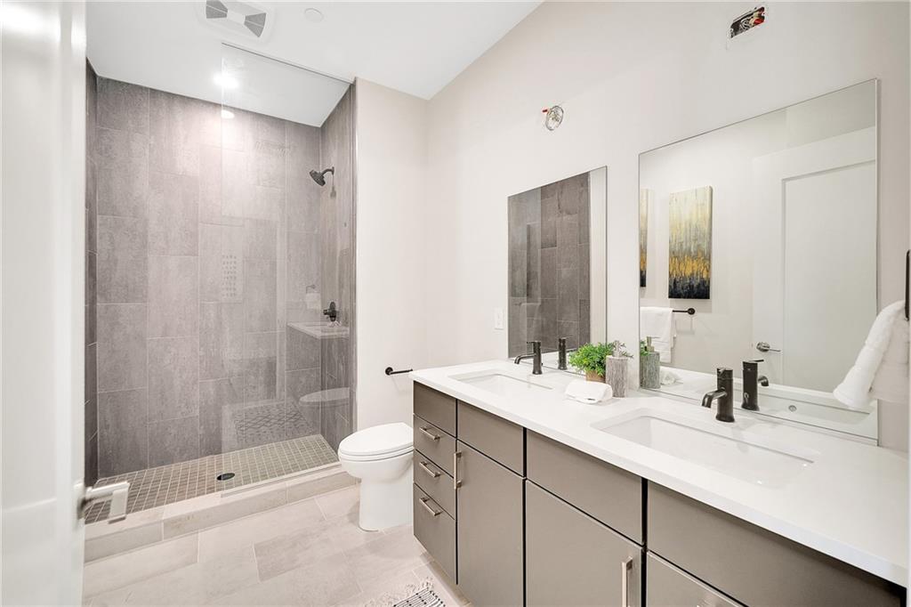 3725 Butler Street, Unit 406 Pittsburgh, PA 15201 - Photo 11 of 21 a bathroom with a double vanity sink toilet and shower