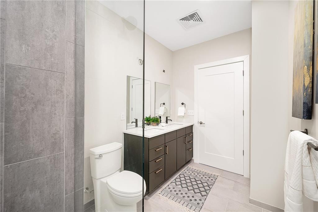 3725 Butler Street, Unit 406 Pittsburgh, PA 15201 - Photo 13 of 21 a bathroom with a toilet a sink and a mirror
