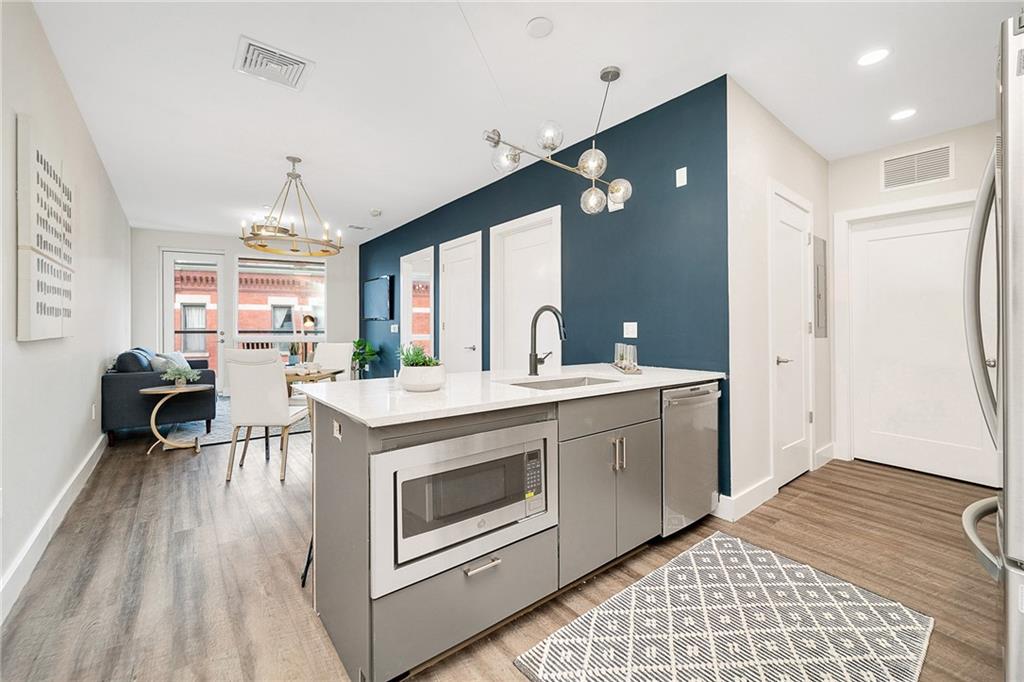 3725 Butler Street, Unit 406 Pittsburgh, PA 15201 - Photo 4 of 21 a kitchen with a stove a sink dishwasher and a refrigerator
