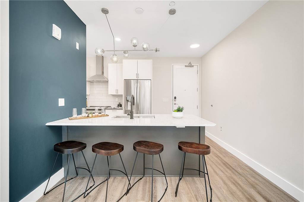 3725 Butler Street, Unit 406 Pittsburgh, PA 15201 - Photo 6 of 21 a view of a kitchen counter space a sink and chairs