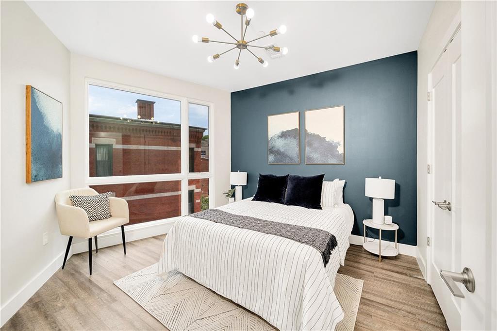 3725 Butler Street, Unit 406 Pittsburgh, PA 15201 - Photo 9 of 21 a bedroom with a bed and a chair with the potted plant