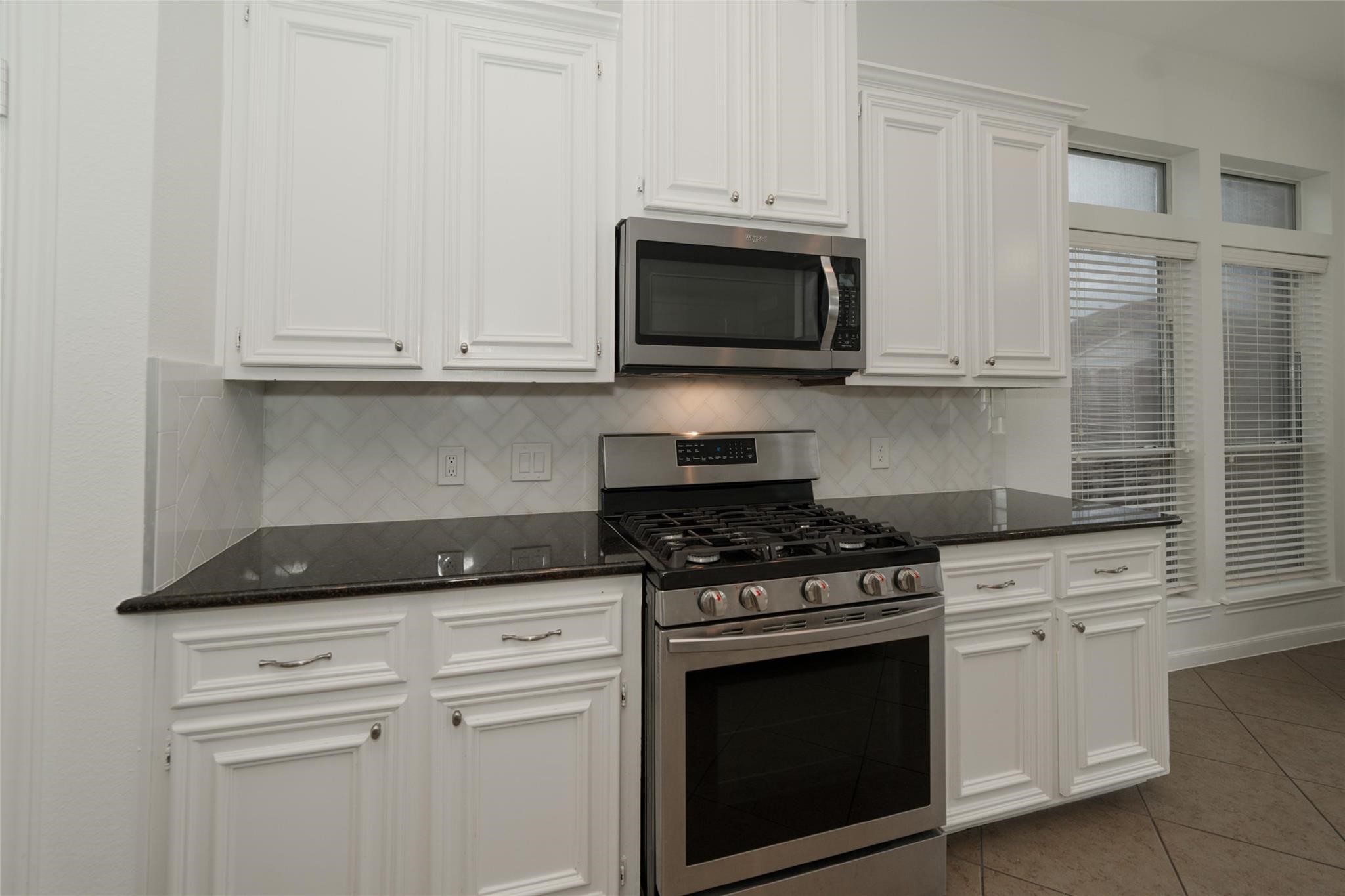 14830 Barton Grove Lane Humble, TX 77396 - Photo 12 of 36 a kitchen with white cabinets and stainless steel appliances
