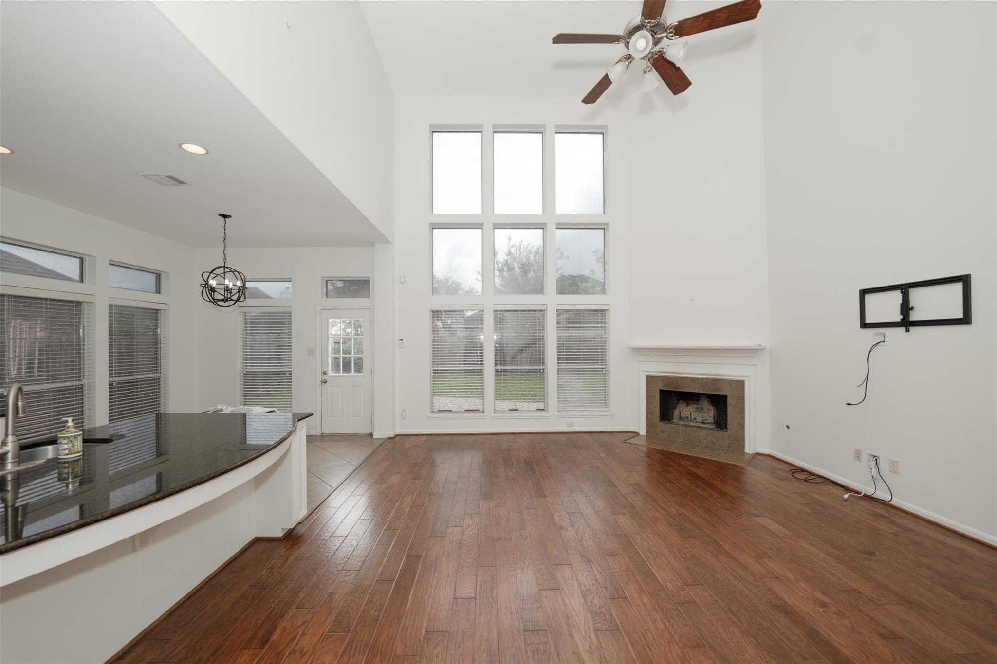14830 Barton Grove Lane Humble, TX 77396 - Photo 7 of 36 an empty room with wooden floor a fireplace and windows