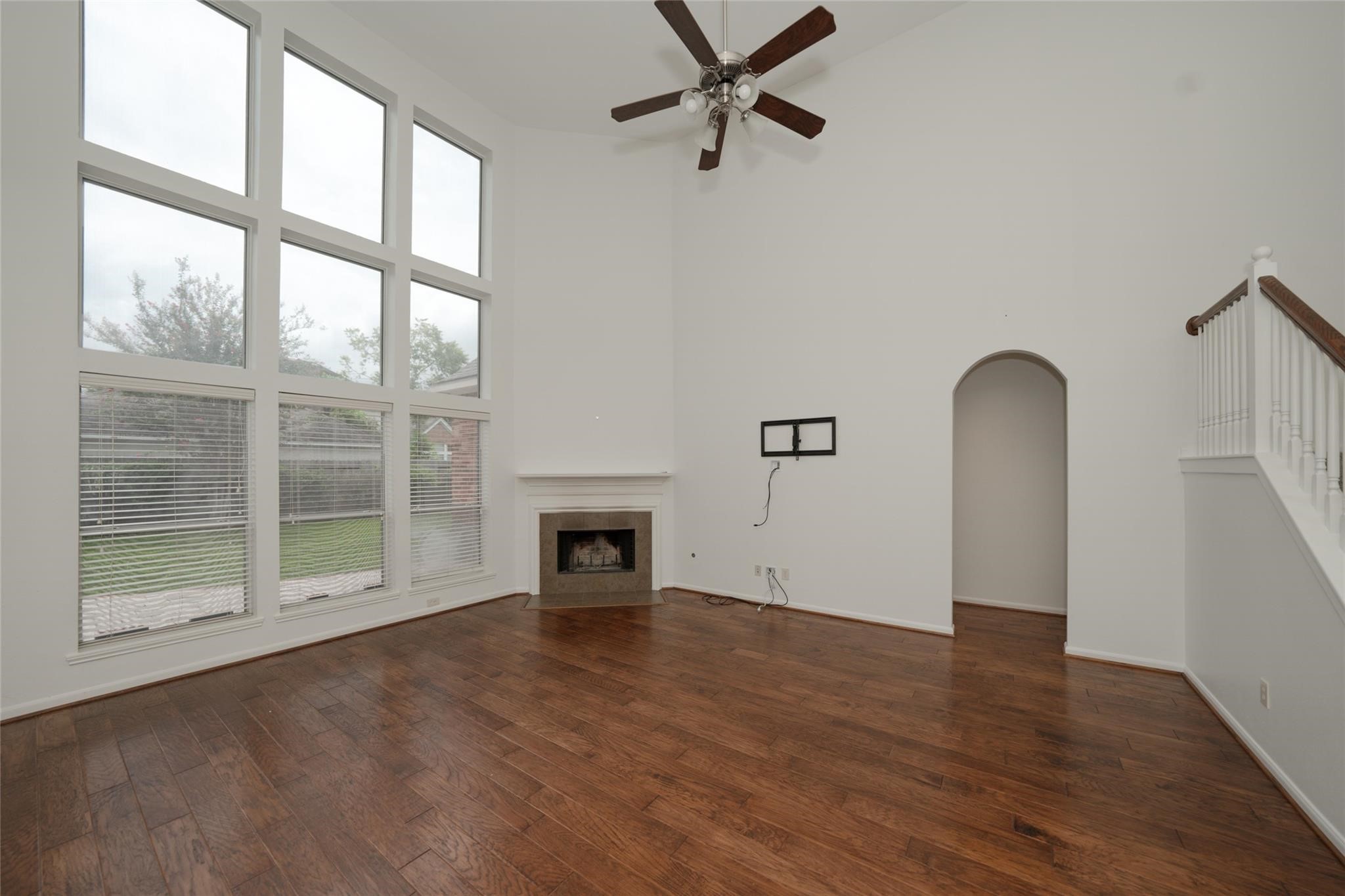 14830 Barton Grove Lane Humble, TX 77396 - Photo 8 of 36 an empty room with wooden floor a ceiling fan and windows