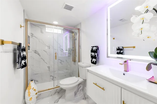 a bathroom with a sink vanity mirror and toilet