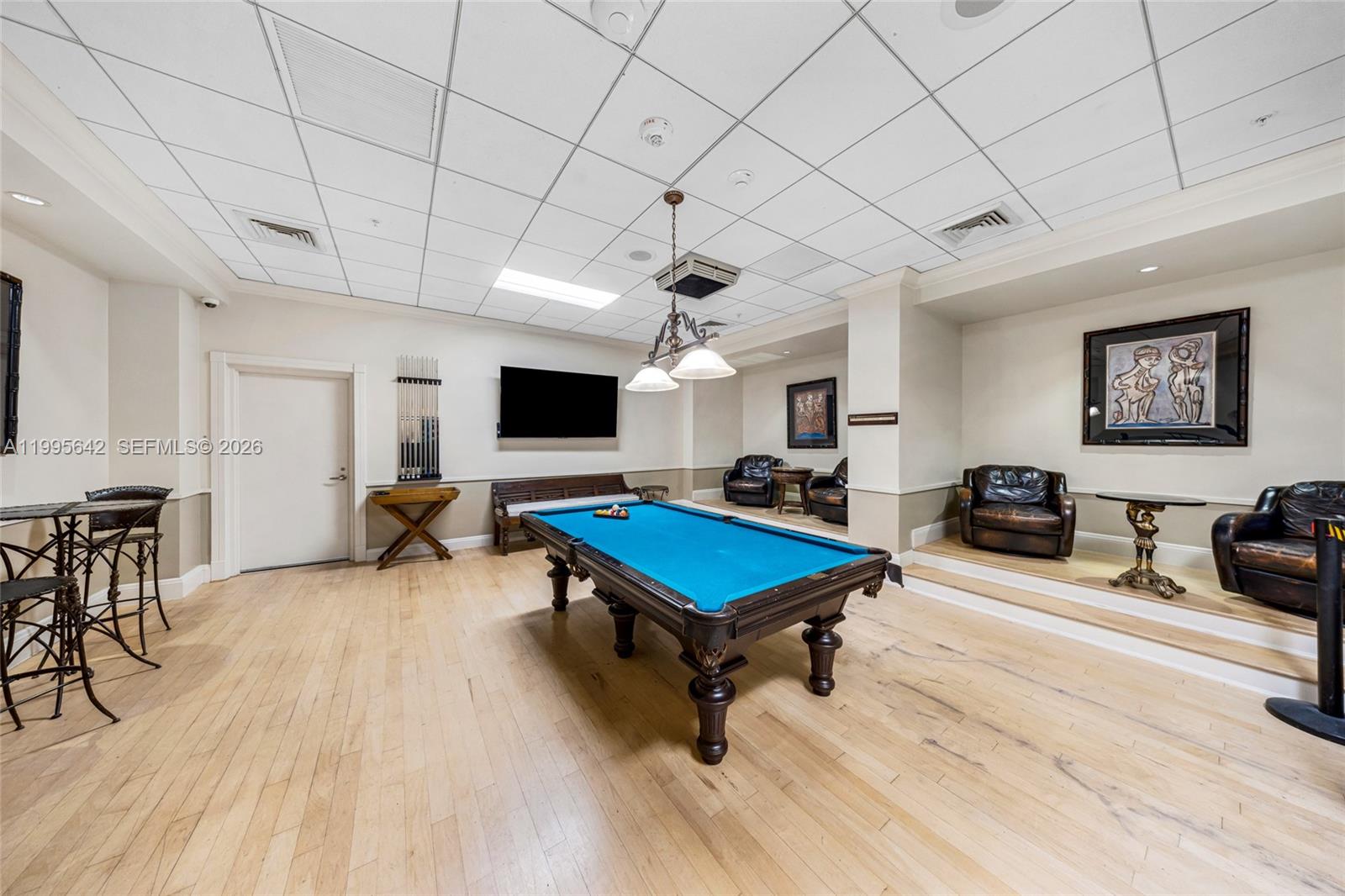 701 Brickell Key Boulevard, Unit 1112 Miami, FL 33131 - Photo 31 of 31 a living room with furniture pool table flat screen tv and a chandelier
