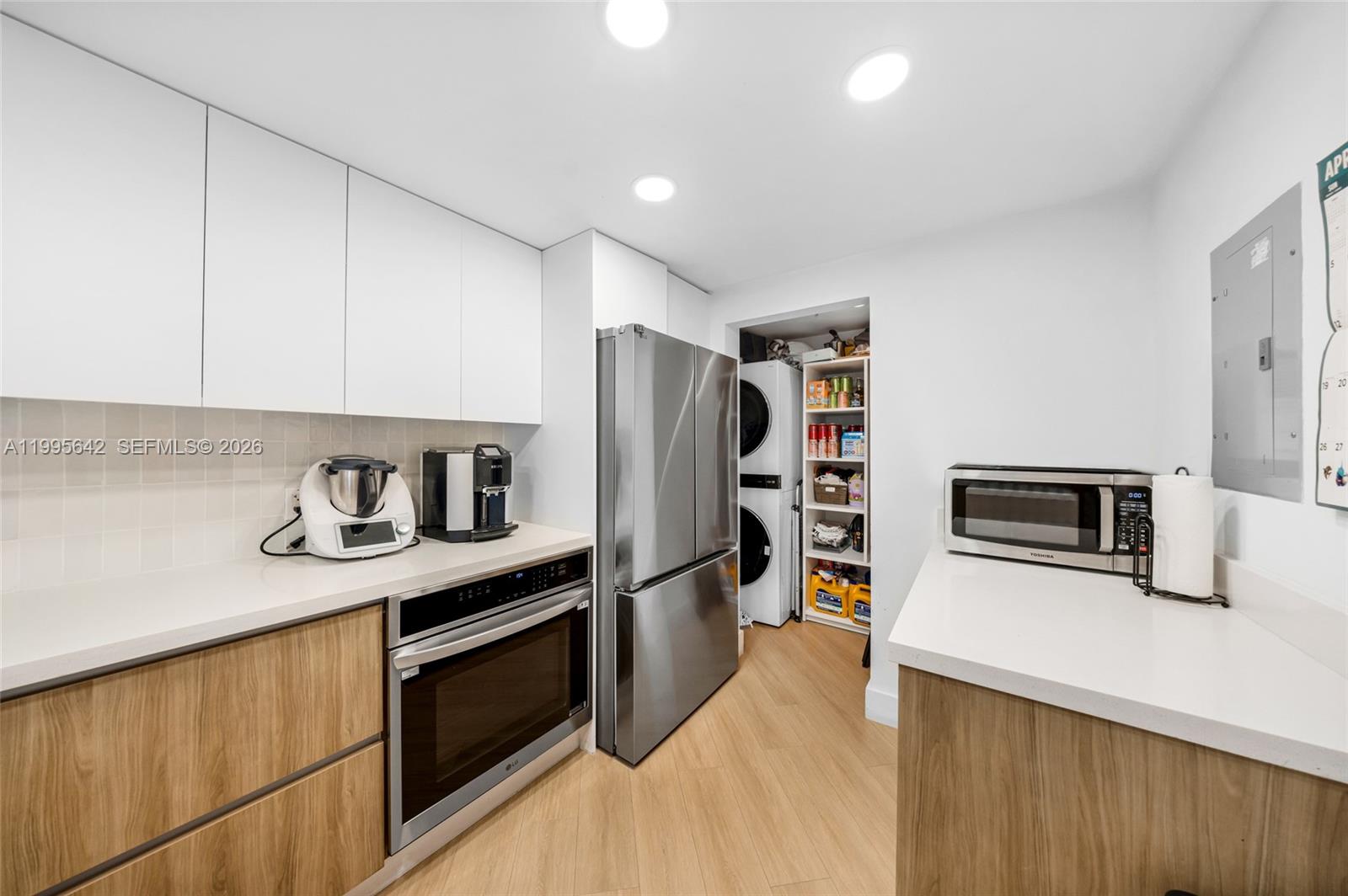 701 Brickell Key Boulevard, Unit 1112 Miami, FL 33131 - Photo 4 of 31 a kitchen with stainless steel appliances a stove a microwave and a refrigerator