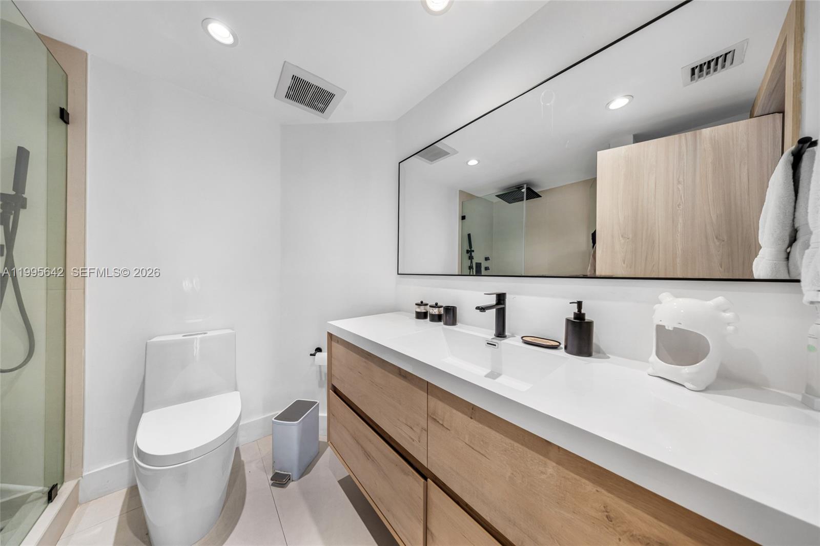 701 Brickell Key Boulevard, Unit 1112 Miami, FL 33131 - Photo 9 of 31 a bathroom with a toilet sink and mirror