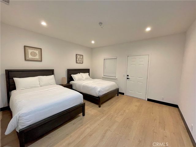 a bedroom with two beds and a desk