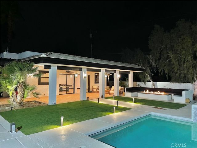 a front view of a house with swimming pool and patio