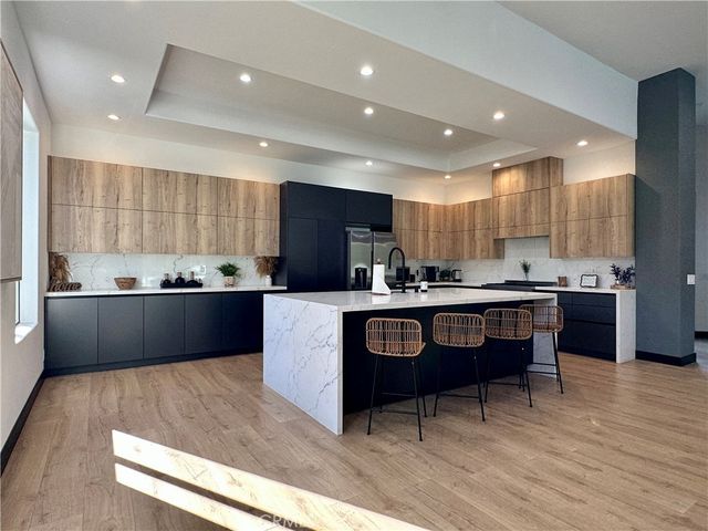 a kitchen with stainless steel appliances kitchen island granite countertop a stove a sink and a refrigerator