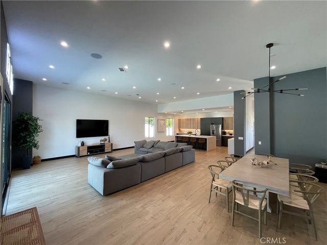 a living room with furniture a flat screen tv and kitchen view